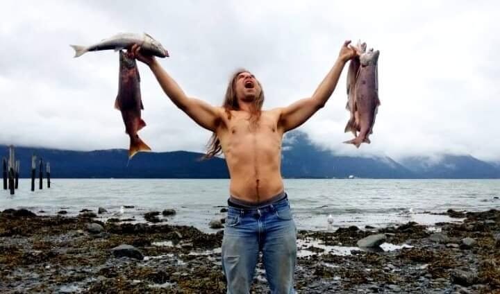 Russ celebrating while holding freshly caught fish