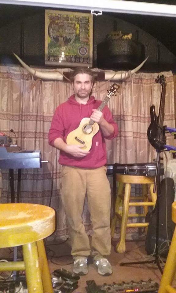 Russ holding a ukulele beneath a set of long horns