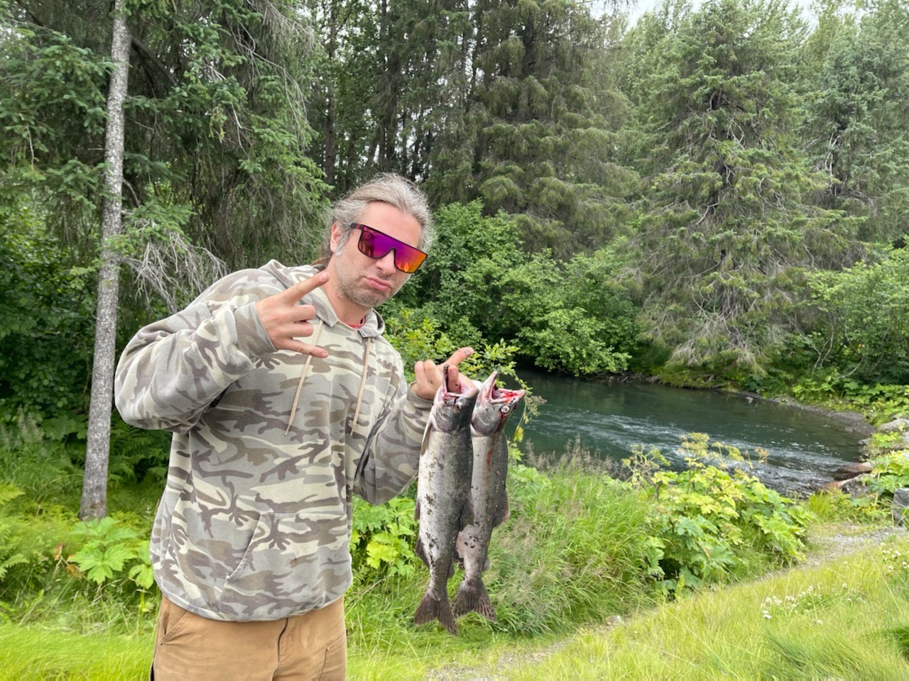 Russ with two salmon beside an Alaska river