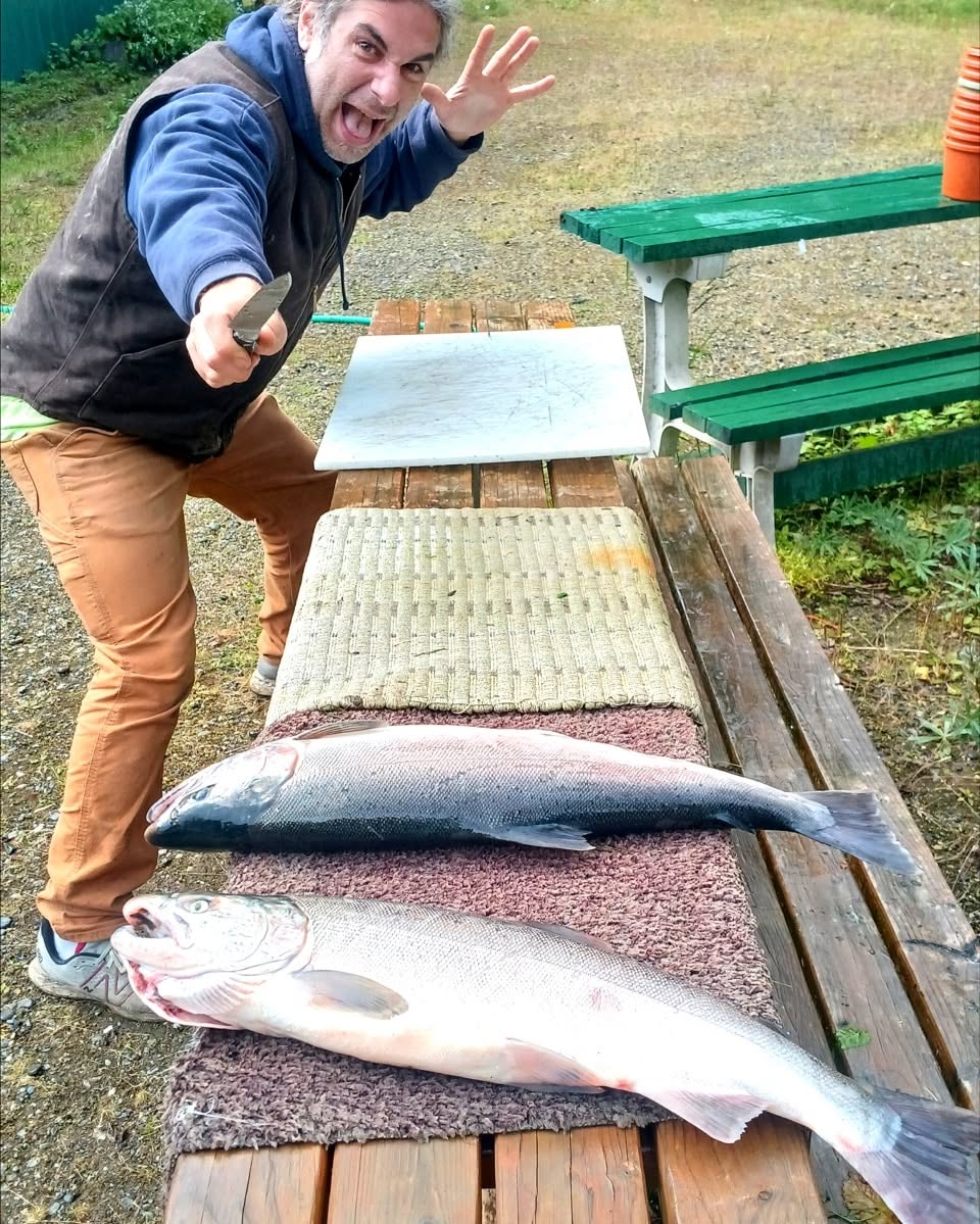 Russ celebrating beside two freshly caught Alaska salmon