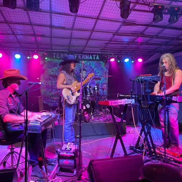 Ukulele Russ performing with a full band under stage lights